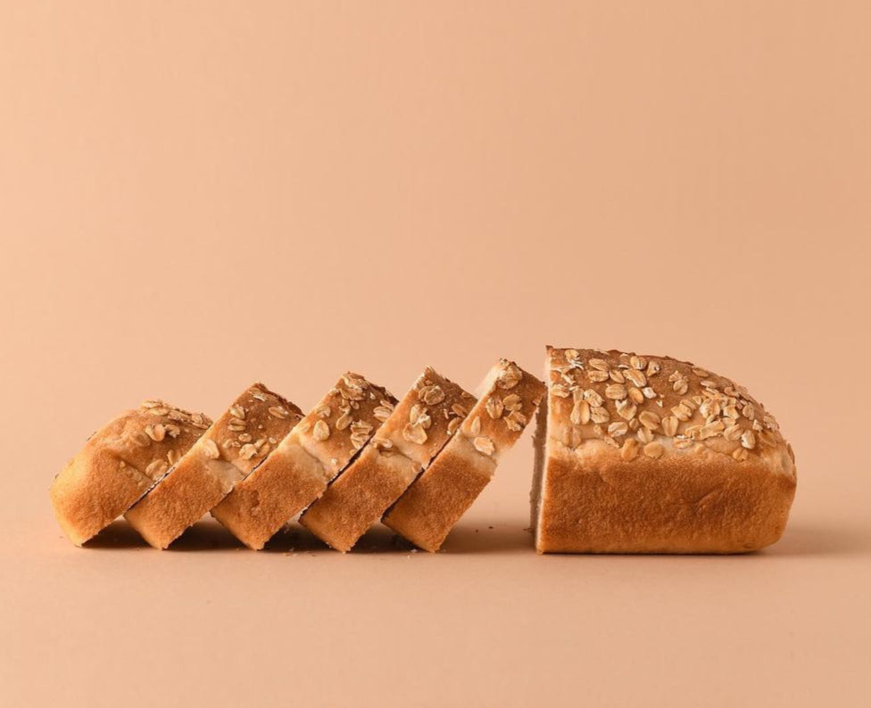 Loaf of bread sliced on a beige background.